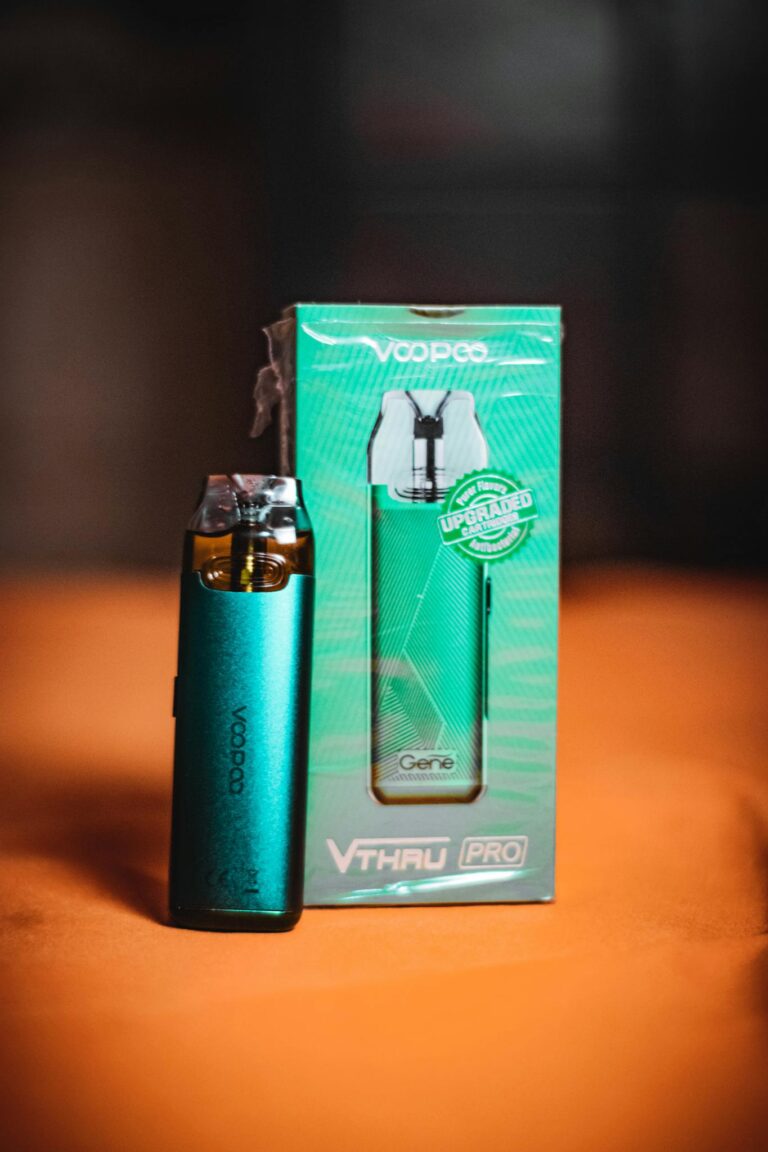 Close-up of a turquoise VooPoo vape and its packaging, perfect for product photography.